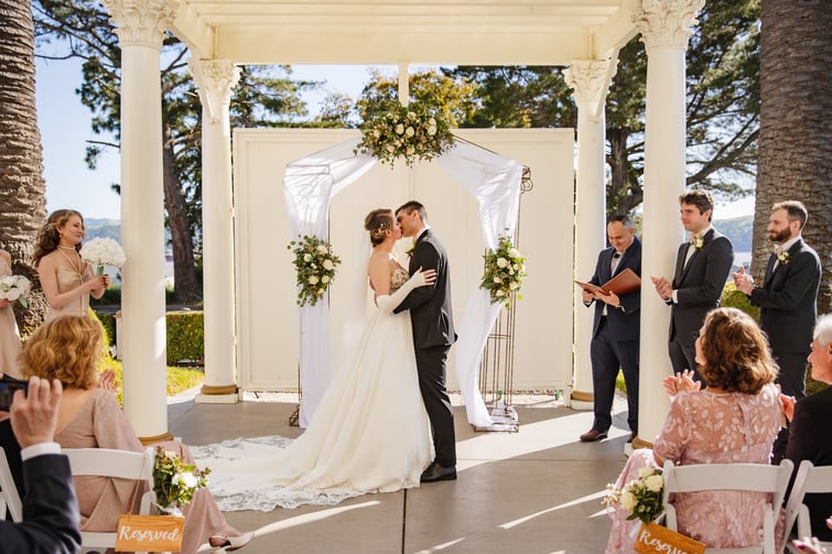 Couple kissing during ceremony at Jefferson Street Mansion by Wedgewood Weddings