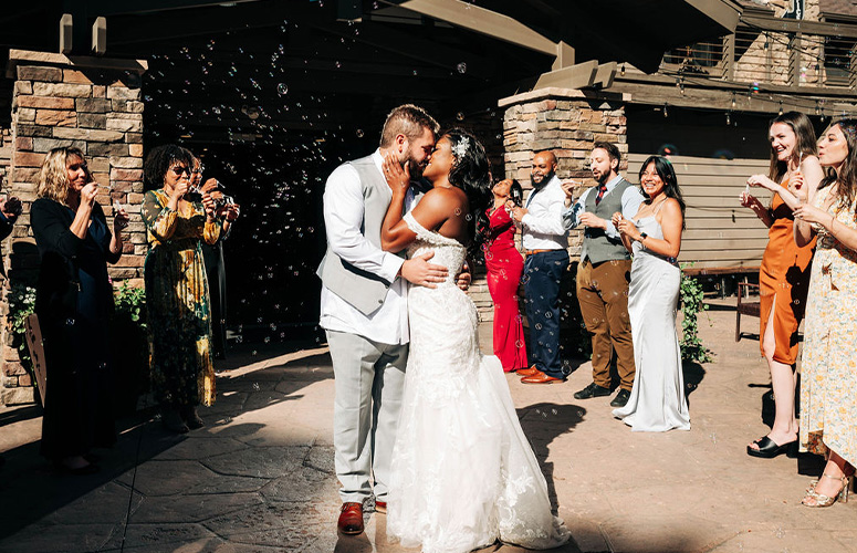 Couple kissing during their grand bubble exit - Boulder Creek by Wedgewood Weddings