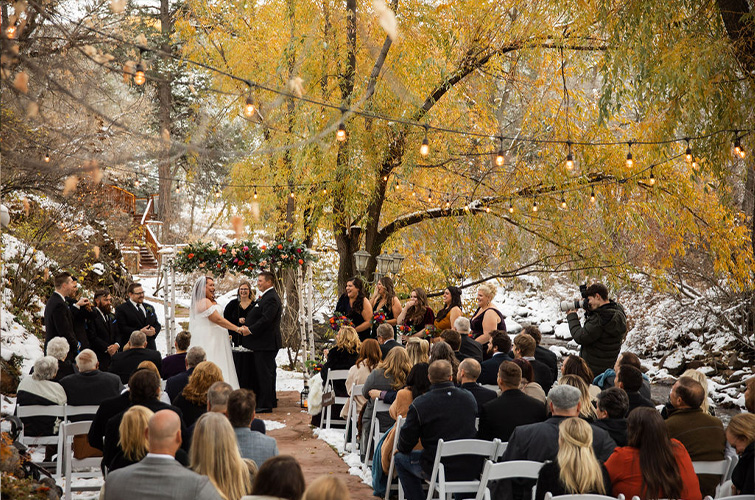 Creekside ceremony underway with snow - Boulder Creek by Wedgewood Weddings