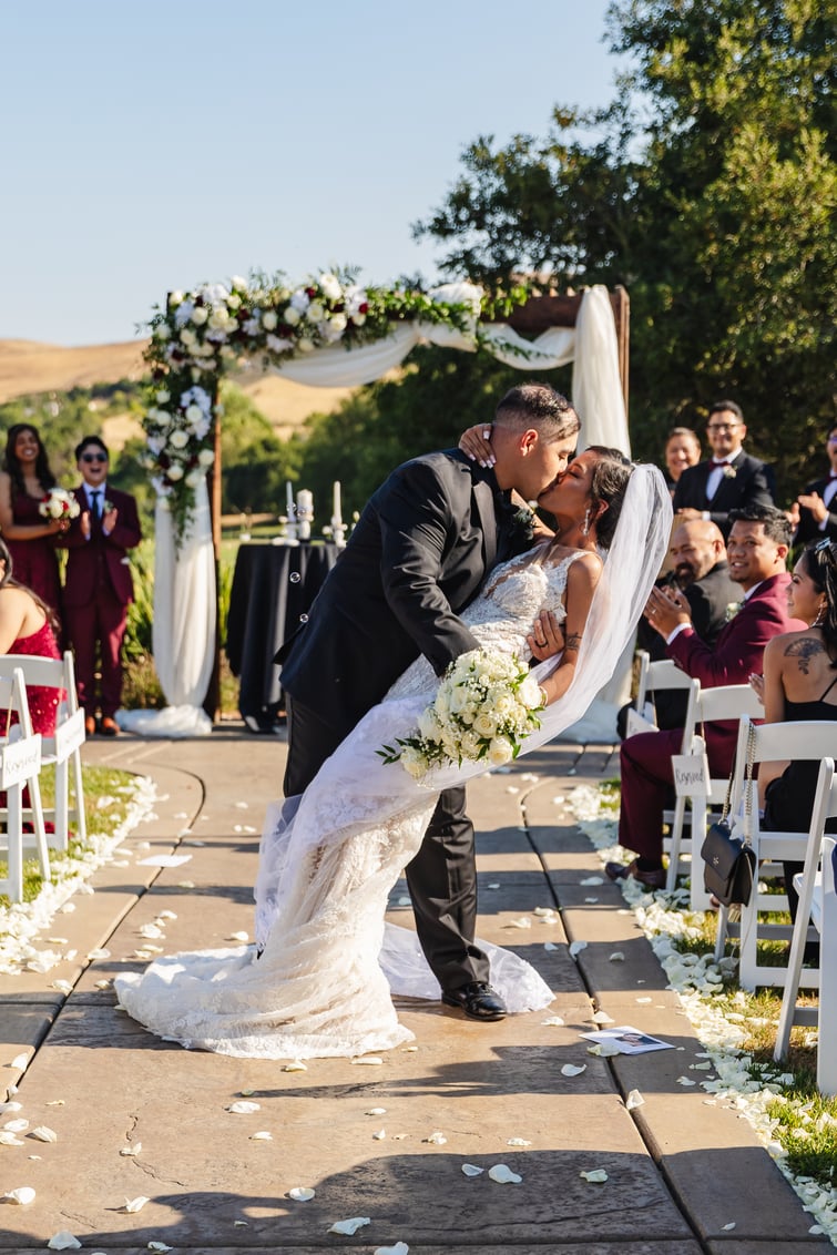 Dip kiss photo during recessional at Hiddenbrooke Hills by Wedgewood Weddings