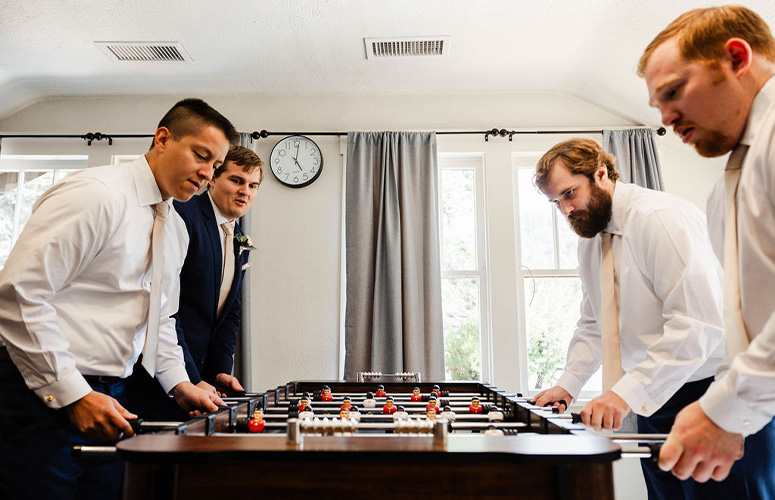 Groomsmen playing foosball in get ready room - Boulder Creek by Wedgewood Weddings