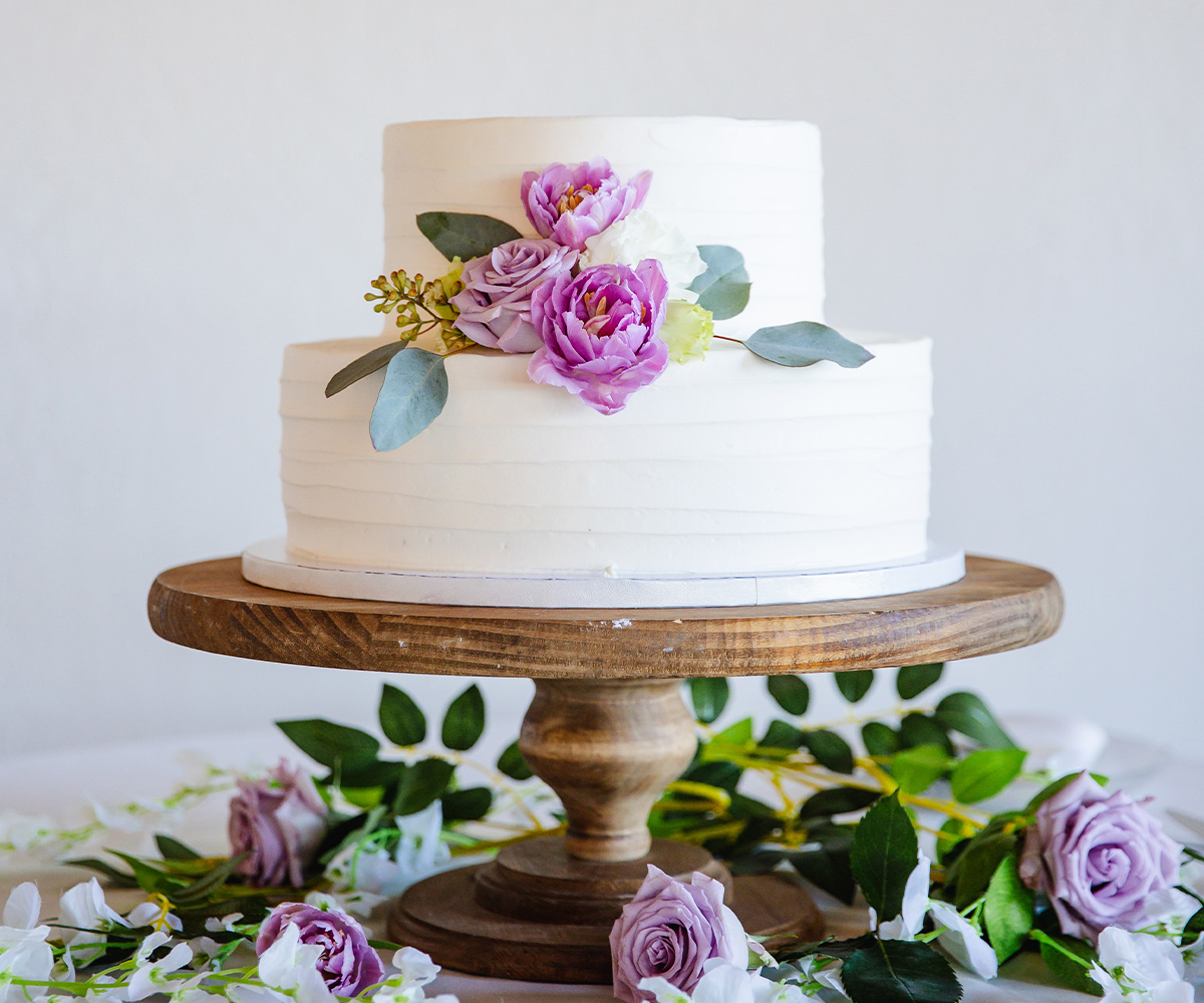 Two tiered white cake with lavender flowers - Carmel Fields by Wedgewood Weddings