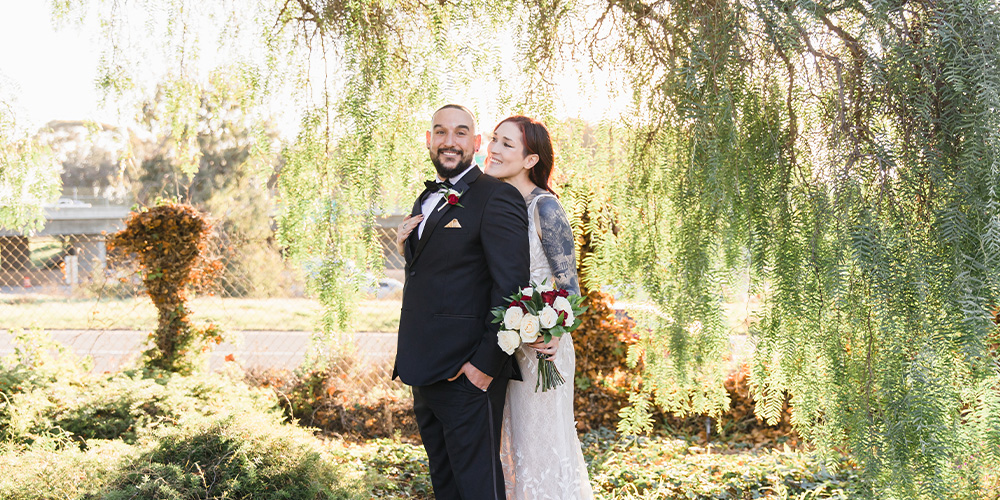 Couple posing in front of trees - Carlsbad Windmill by Wedgewood Weddings