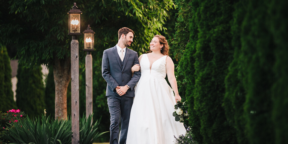 Couple walking in beautiful gardens at Groveland Fairways by Wedgewood Weddings