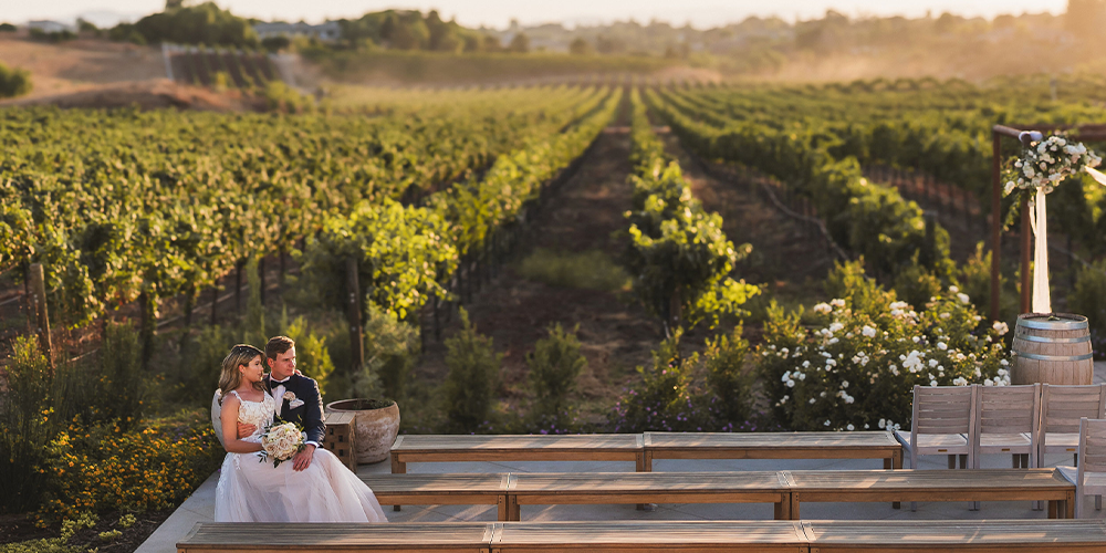 Couple in front of gorgeous vineyard views at Danza del Sol Winery in Temecula, CA