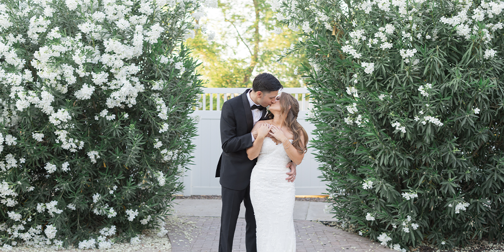 Newlyweds in front of lush greenery at Lindsay Grove in Mesa, Arizona