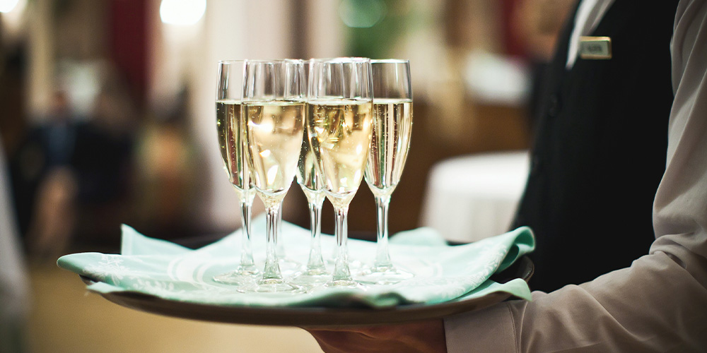 Server carrying tray of champagne glasses