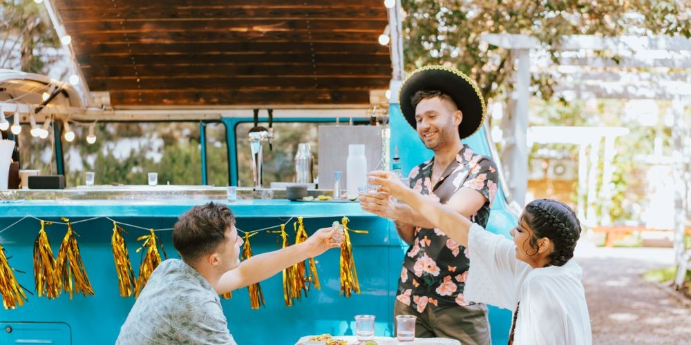 Wedding guests enjoying drinks by a food truck