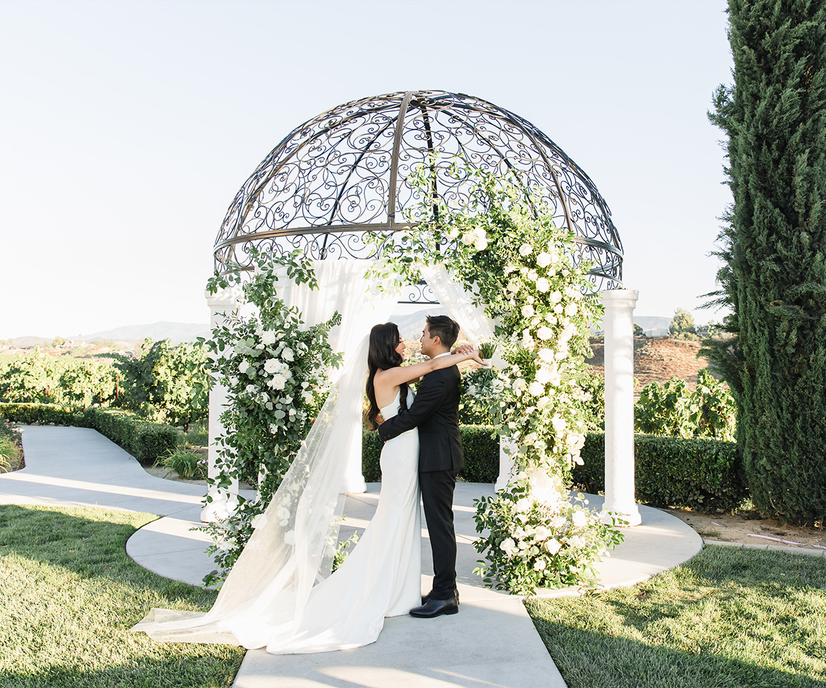 Intimate moment captured between newlyweds against the romantic backdrop of Avensole Winery