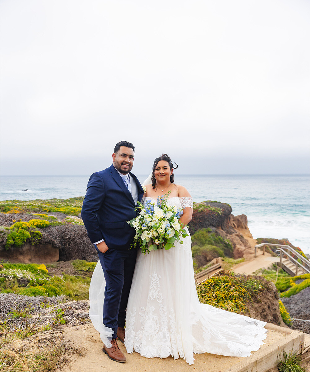 Couple on beach with spring flowers - Carmel Fields by Wedgewood Weddings