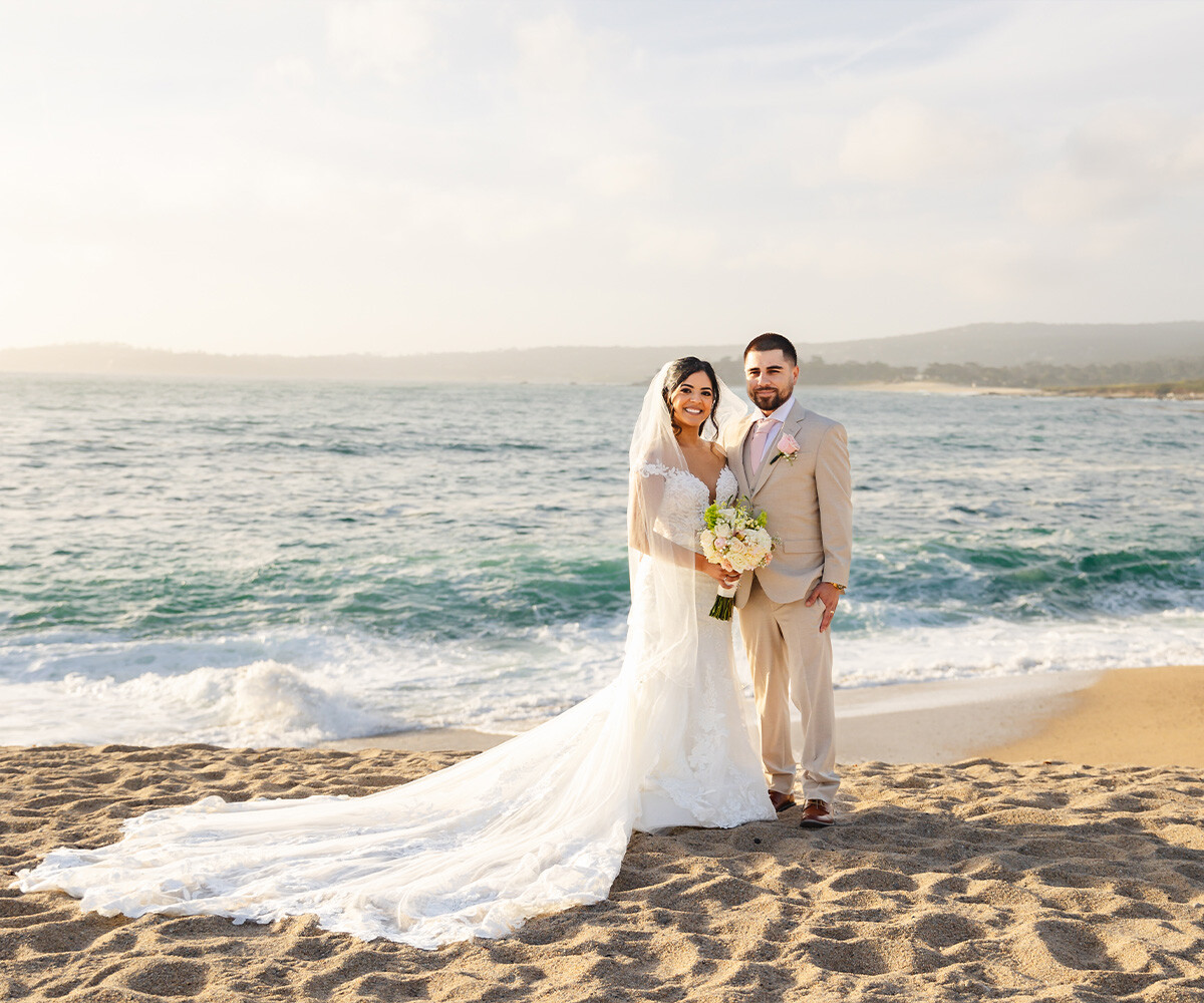 Newlyweds posing on beach - Carmel Fields by Wedgewood Weddings