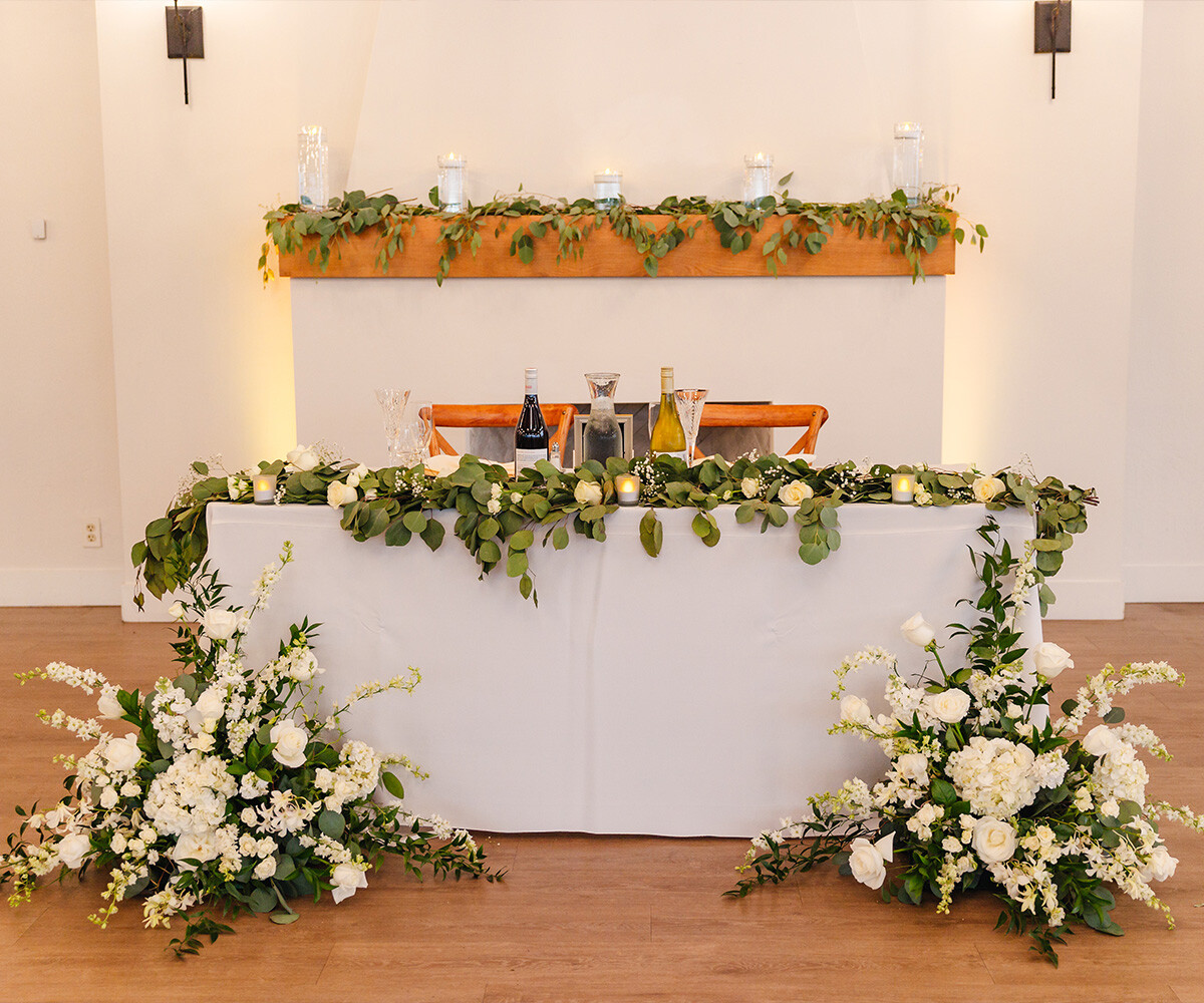 Sweetheart table in front of fireplace with florals - Carmel Fields by Wedgewood Weddings