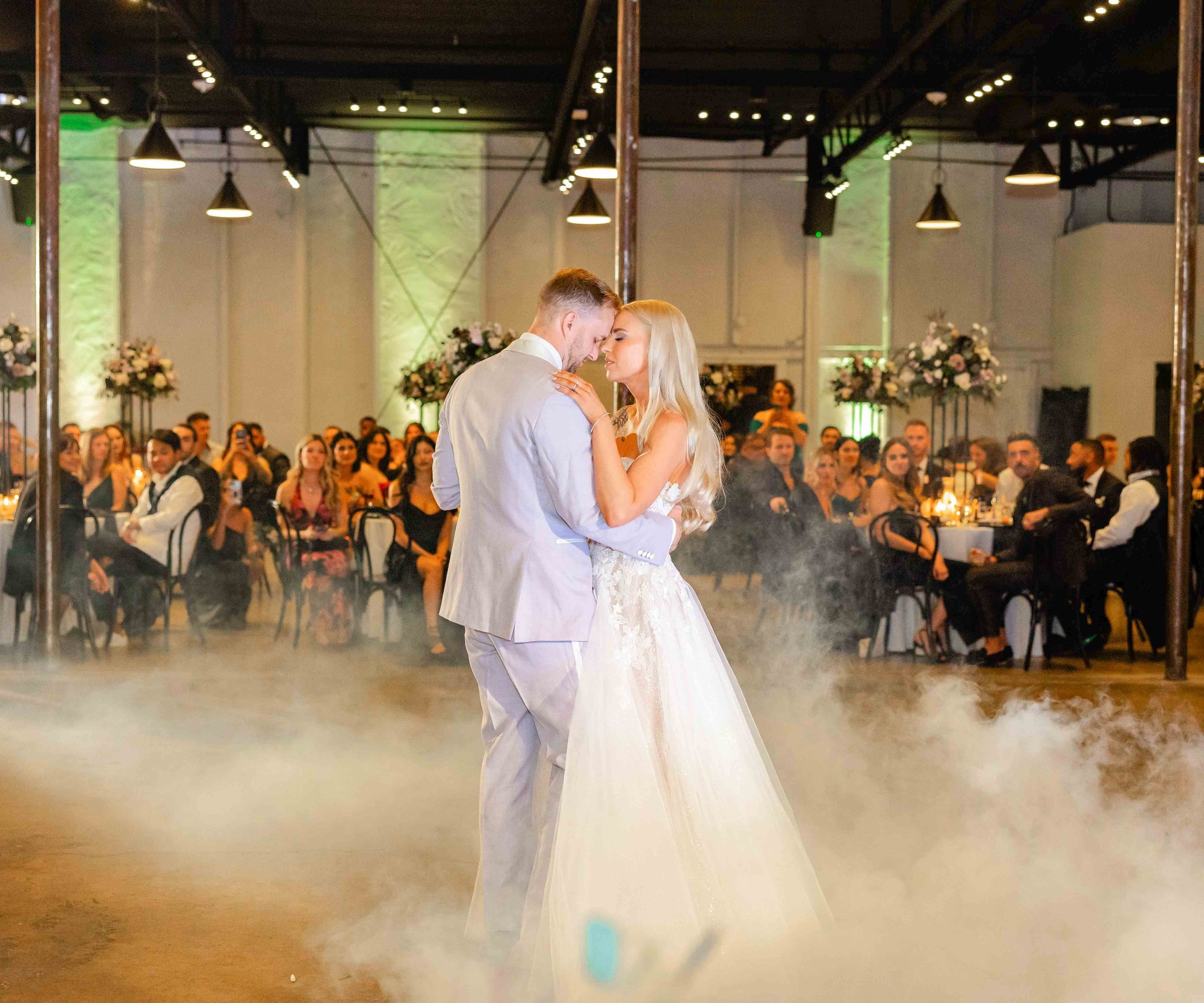 Dramatic first dance photo of newlyweds surrounded by fog effects at Phoenix wedding venue 