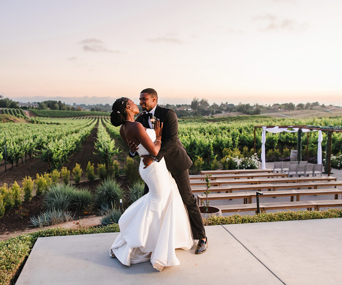 Couple posing in front of ceremony and views - Danza del Sol Winery by Wedgewood Weddings