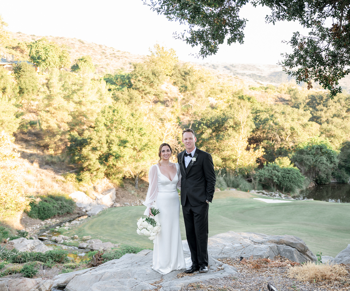 Couple standing on a rocky outcrop overlooking the Dove Canyon golf course