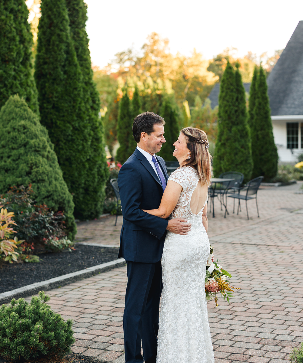 Couple embracing in courtyard at Groveland Fairways by Wedgewood Weddings