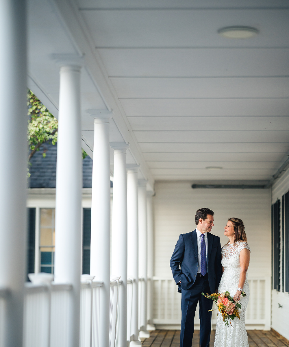 Newlyweds on front porch of Groveland Fairways by Wedgewood Weddings