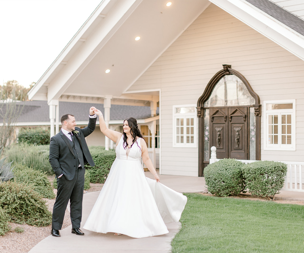 Couple twirling in front of wooden doors at Lindsay Grove by Wedgewood Weddings