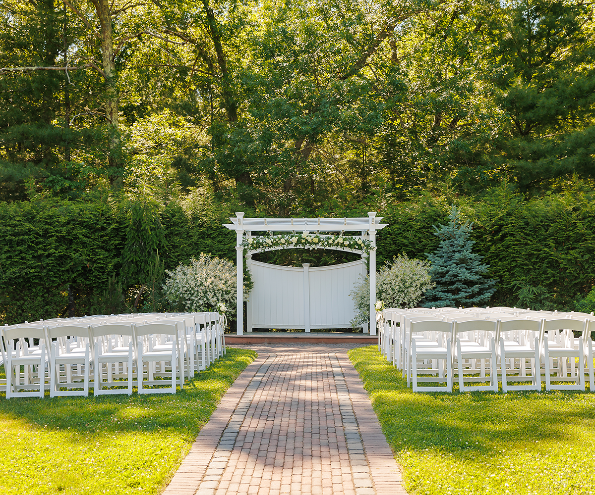 White pergola with flowers and lush greenery - Miraval Gardens by Wedgewood Weddings