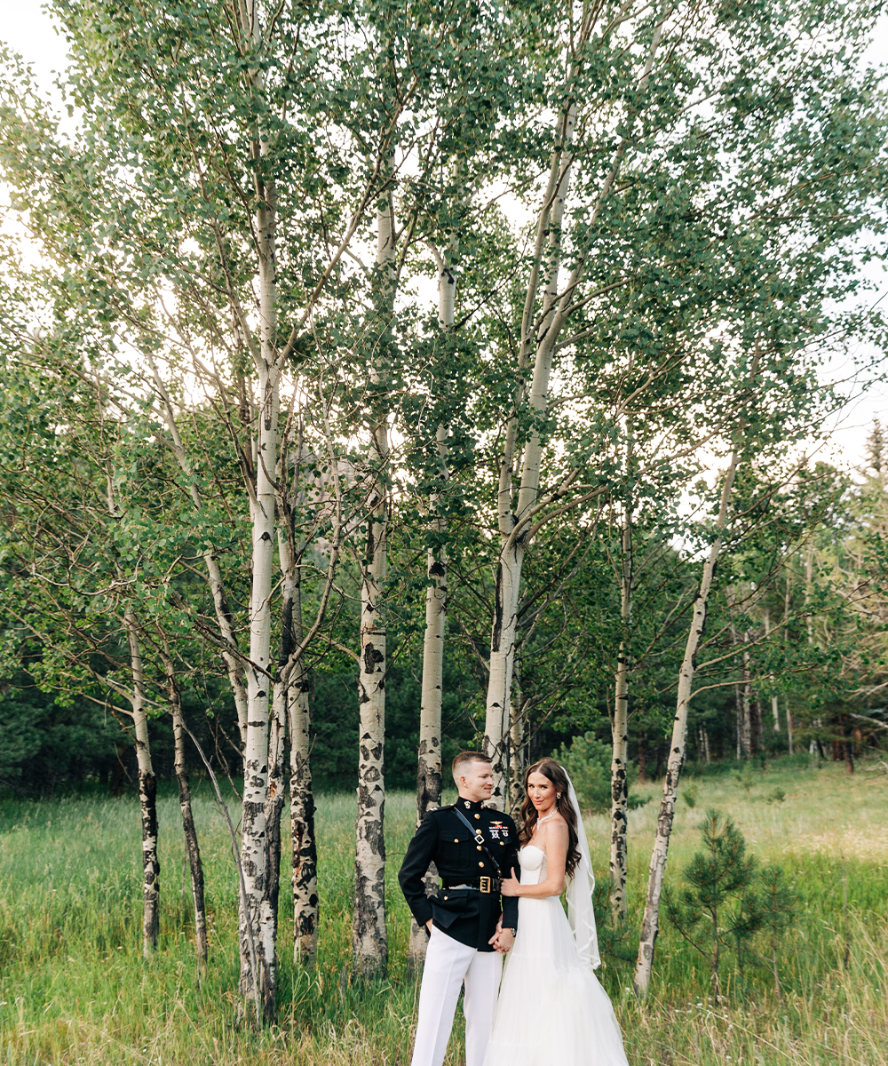 Newlyweds in meadow in front of aspen trees - Lake View at Mountain View Ranch