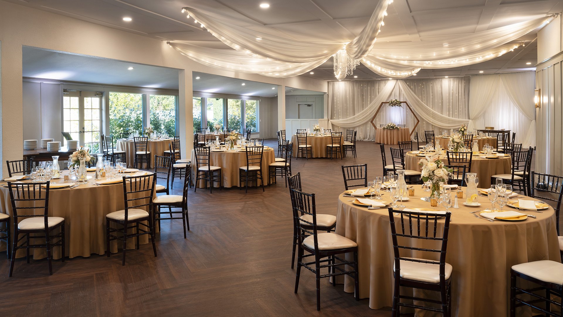 Indoor Wedding Reception Hall with Beautiful Table Settings, Crystal Chandelier and Fabric Ceiling Treatment