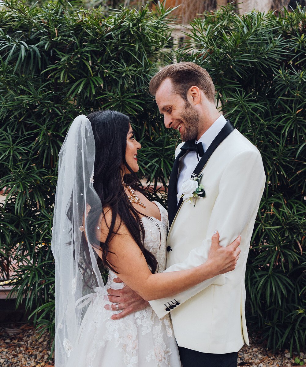 Couple embracing in front of greenery - Sterling Hotel by Wedgewood Weddings