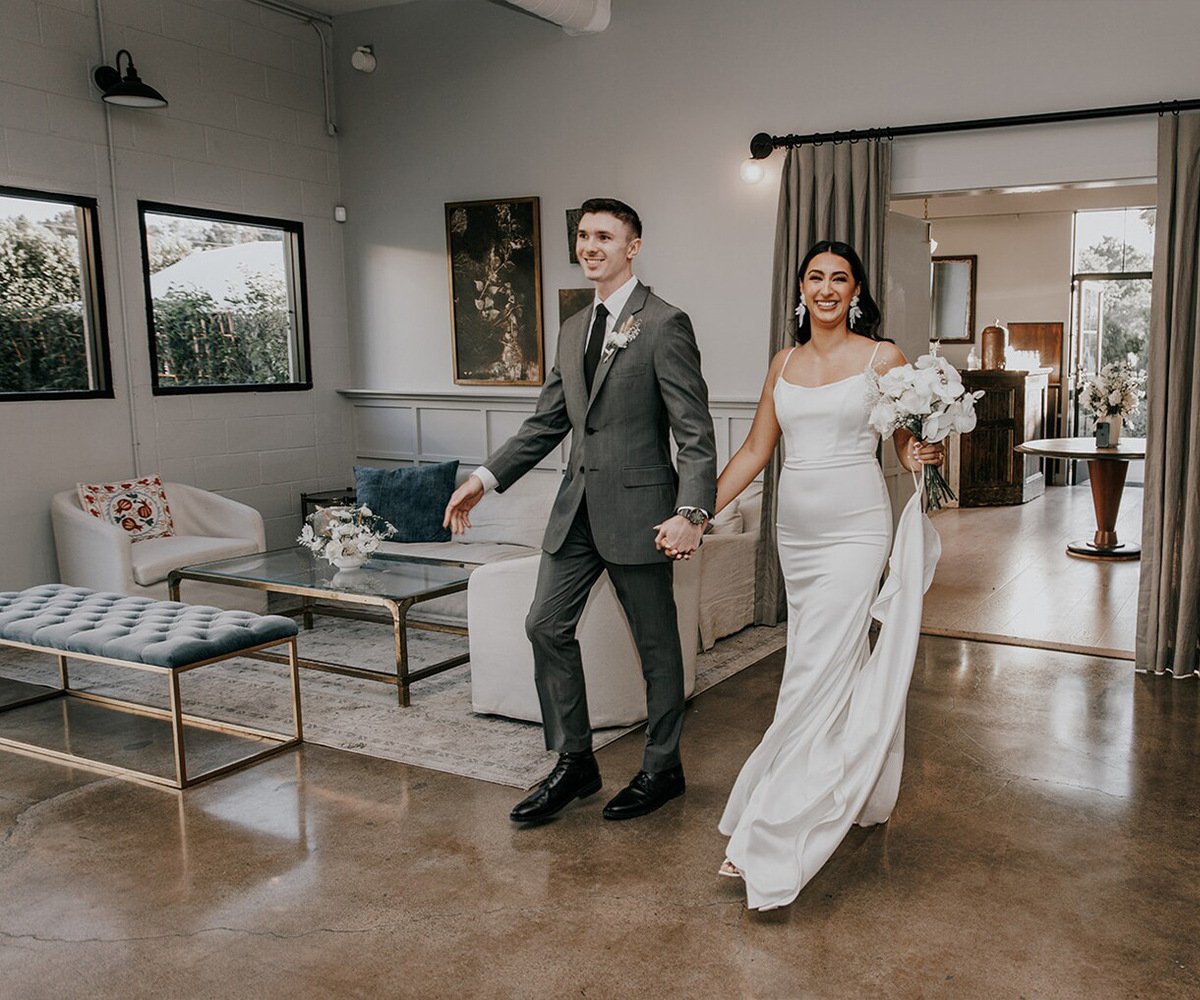 Modern lounge at The Harper Costa Mesa featuring contemporary furniture, polished concrete floors, and newlyweds in classic wedding attire