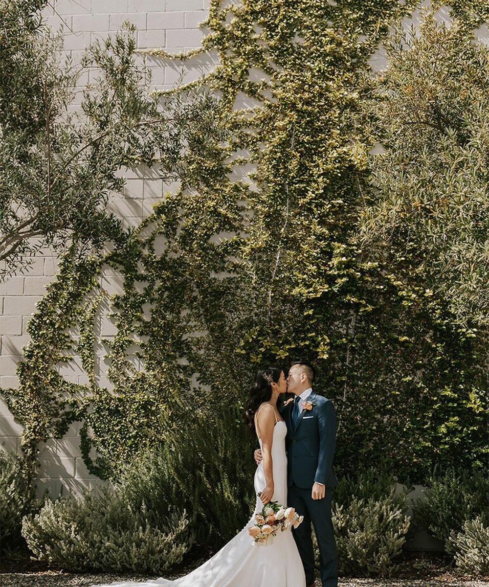 Romantic couple portraits at The Harper surrounded by olive trees and climbing vines - modern Costa Mesa wedding venue backdrop