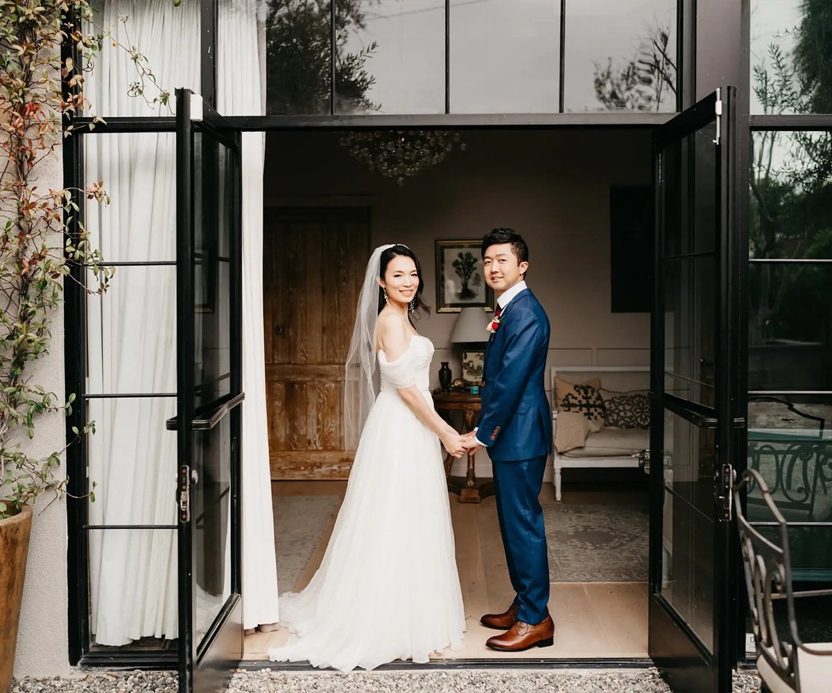 Elegant couple portraits in The Harper's French doors featuring modern interior design and climbing vines