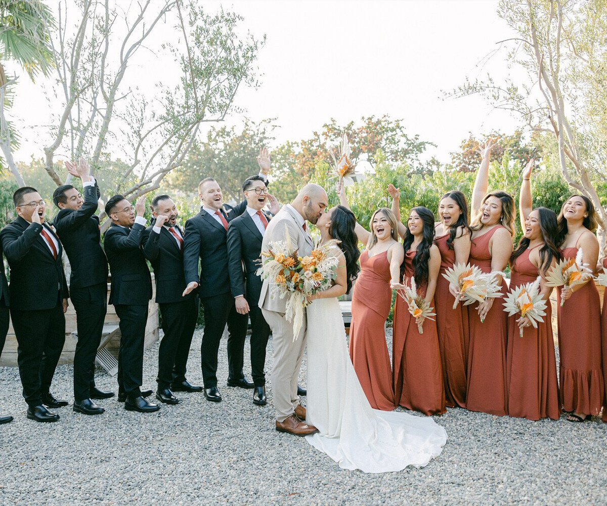 Fun bridal party photos at The Harper featuring terracotta bridesmaid dresses, palm trees and modern landscaping