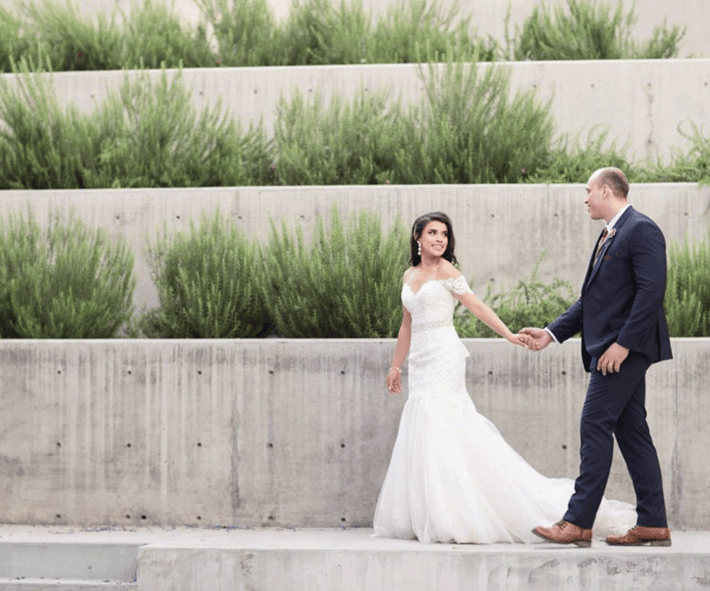 Couple walking in front of greenery wall at Tre Bella