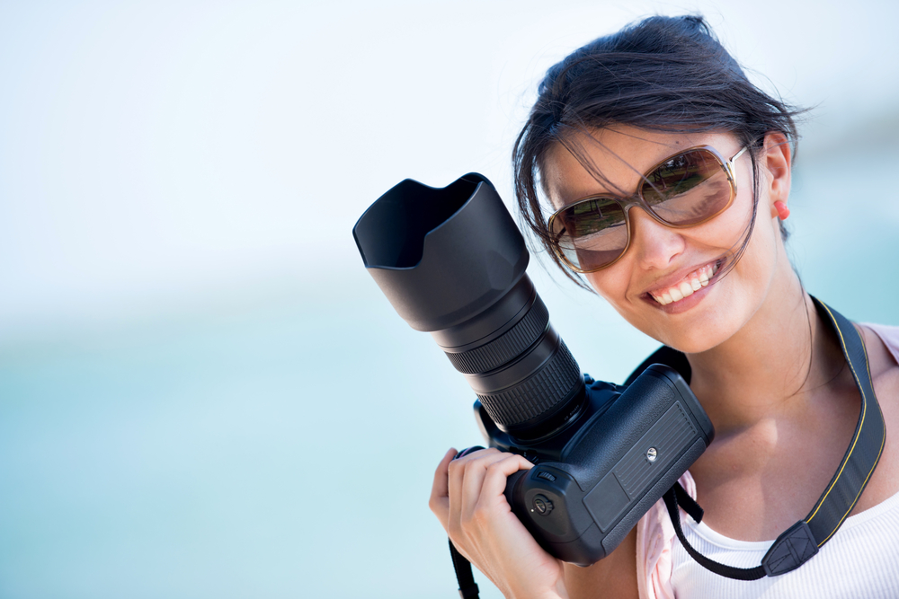 Professional videographer holding a camera and smiling