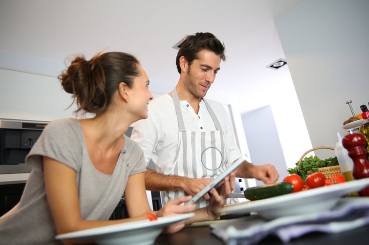 Copule in home kitchen looking at recipe on the web-1