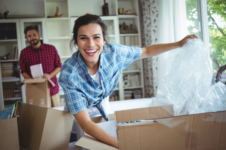 Happy couple unpacking cartons in their new house