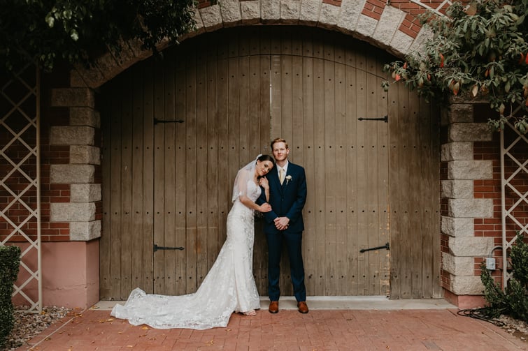 Macie and William in front of the rustic doors at Stonebridge Manor