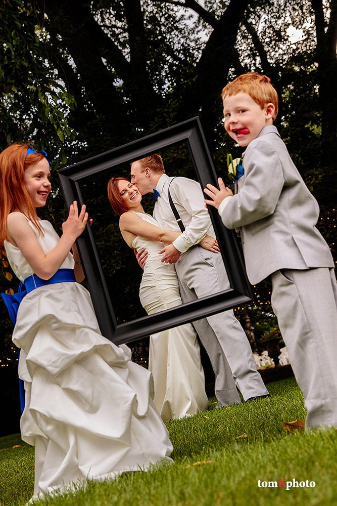 flower girl and ring bearer holding wedding frame